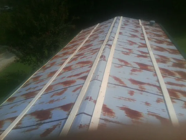 Rusted metal roof panels with new wood purlins before replacement — Storm Damage Roof Repair in Hubert by Roofing Brothers