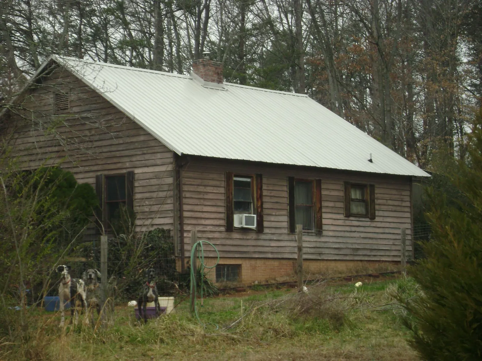 White metal roof on an old wood sided farmhouse, from a Metal Roof Installation job in Hubert